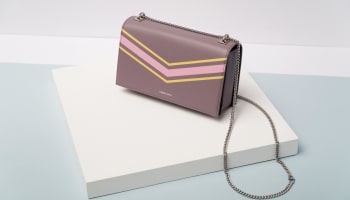 a purple and pink purse on a white surface