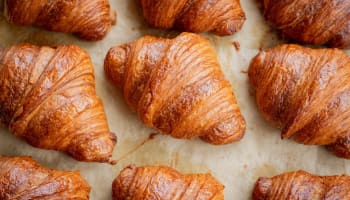 a group of croissants on a baking sheet