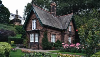 a brick house with flowers and trees