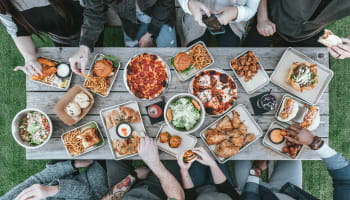 a group of people sitting around a table with food