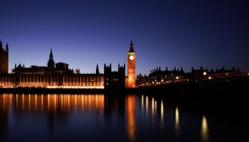 a clock tower and a building with a bridge and a body of water