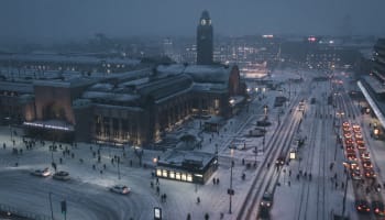 a snowy city street with people and cars