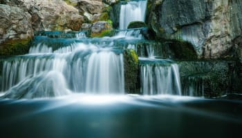 a waterfall with rocks and trees