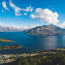 a body of water with a city and mountains in the background