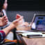 a person clapping hands in front of a laptop