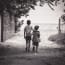 two children holding hands walking on a path