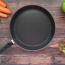 a pan with a handle and a few carrots on a wood surface