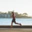 a person running on a road near water