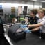 two women in uniform looking at a dog and luggage