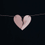 a paper heart with a broken piece of paper attached to a string