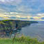 a cliff with grass and water