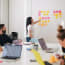 a person pointing at a wall with many sticky notes