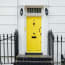 a yellow door with black railings