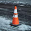 an orange and white cone on a road