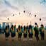 a group of people in graduation gowns throwing hats in the air