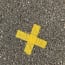 a yellow cross on the ground