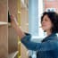 a person looking at a book on a shelf