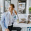 a person sitting at a table with a laptop and phone