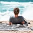 a person lying on the sand looking at the ocean