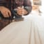 a person using a sander to polish a wood surface