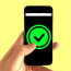 a hand holding a cell phone with a green check mark