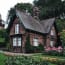 a brick house with flowers and trees