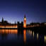 a clock tower and a building with a bridge and a body of water