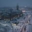 a snowy city street with people and cars