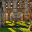 a stone building with columns and grass