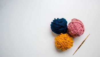 a group of balls of yarn next to a crochet hook
