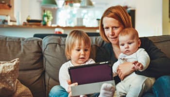a person and two children sitting on a couch