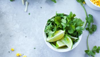 a bowl of cilantro and limes