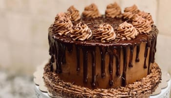 a chocolate cake with frosting and chocolate drizzle