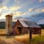 a barn with a tractor and silo in the background