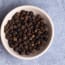a bowl of black peppercorns