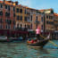 a person in a red and white striped shirt on a gondola in a canal