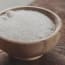 a bowl of salt on a wood surface