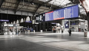 a large room with a large screen and people walking