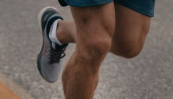 a person's foot wearing a grey and pink shoe
