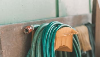 a green hose on a yellow holder