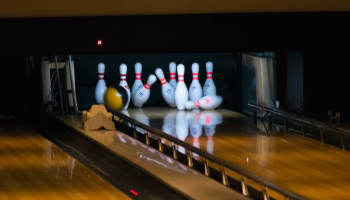 a bowling alley with bowling pins and a ball
