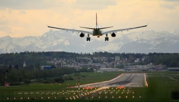 an airplane flying over a runway