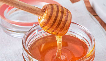a jar of honey with a metal wire lid