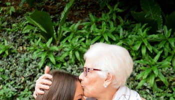 a person kissing another person's forehead