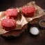raw meat on paper next to salt and pepper