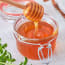 a jar of honey with a metal wire lid