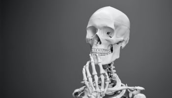 a skeleton with hand on chin