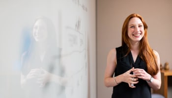 a person standing next to a white board