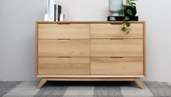 a wooden dresser with a plant on top