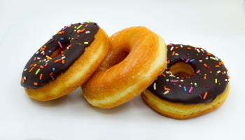 a group of donuts with chocolate frosting and sprinkles